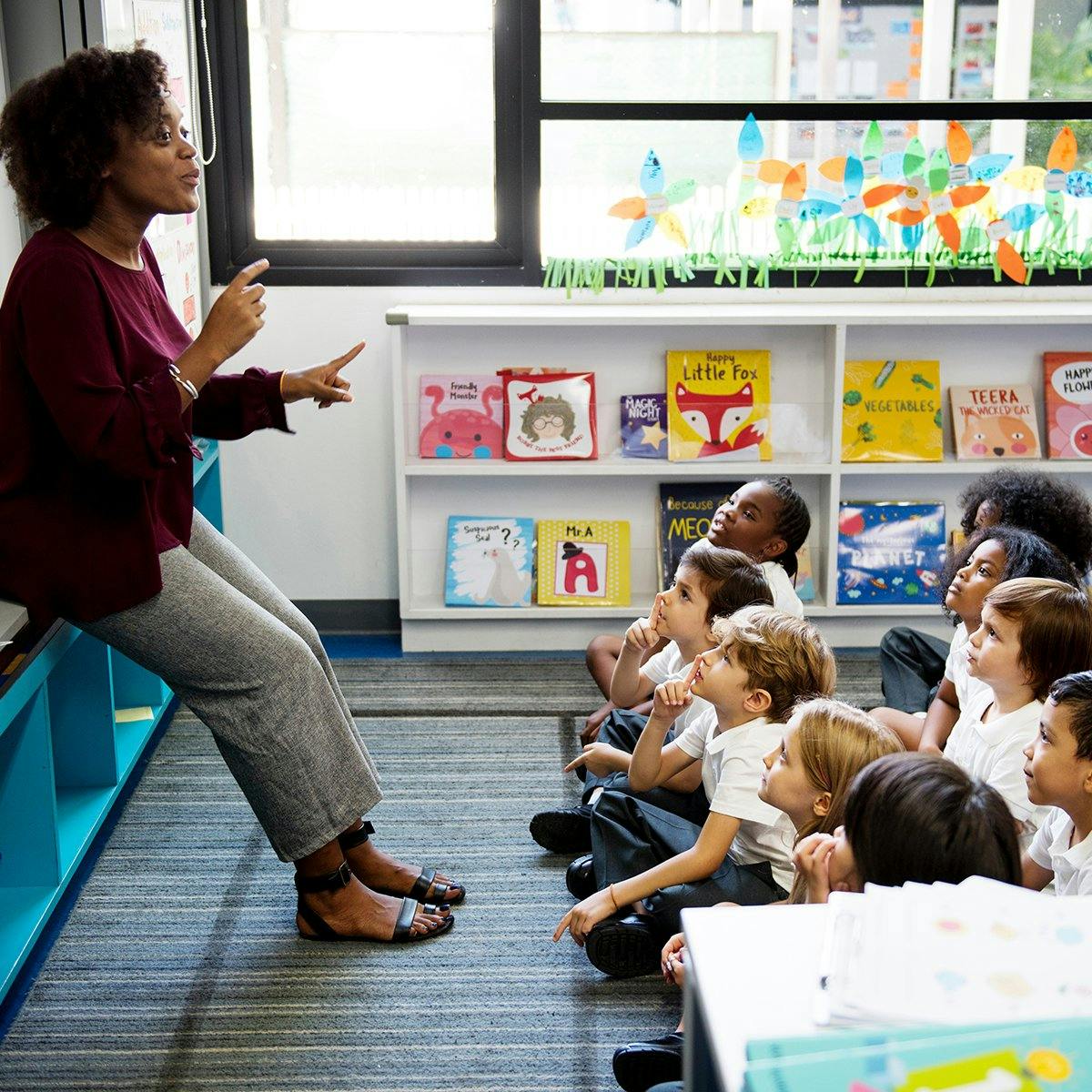 A teacher speaking to a class of children