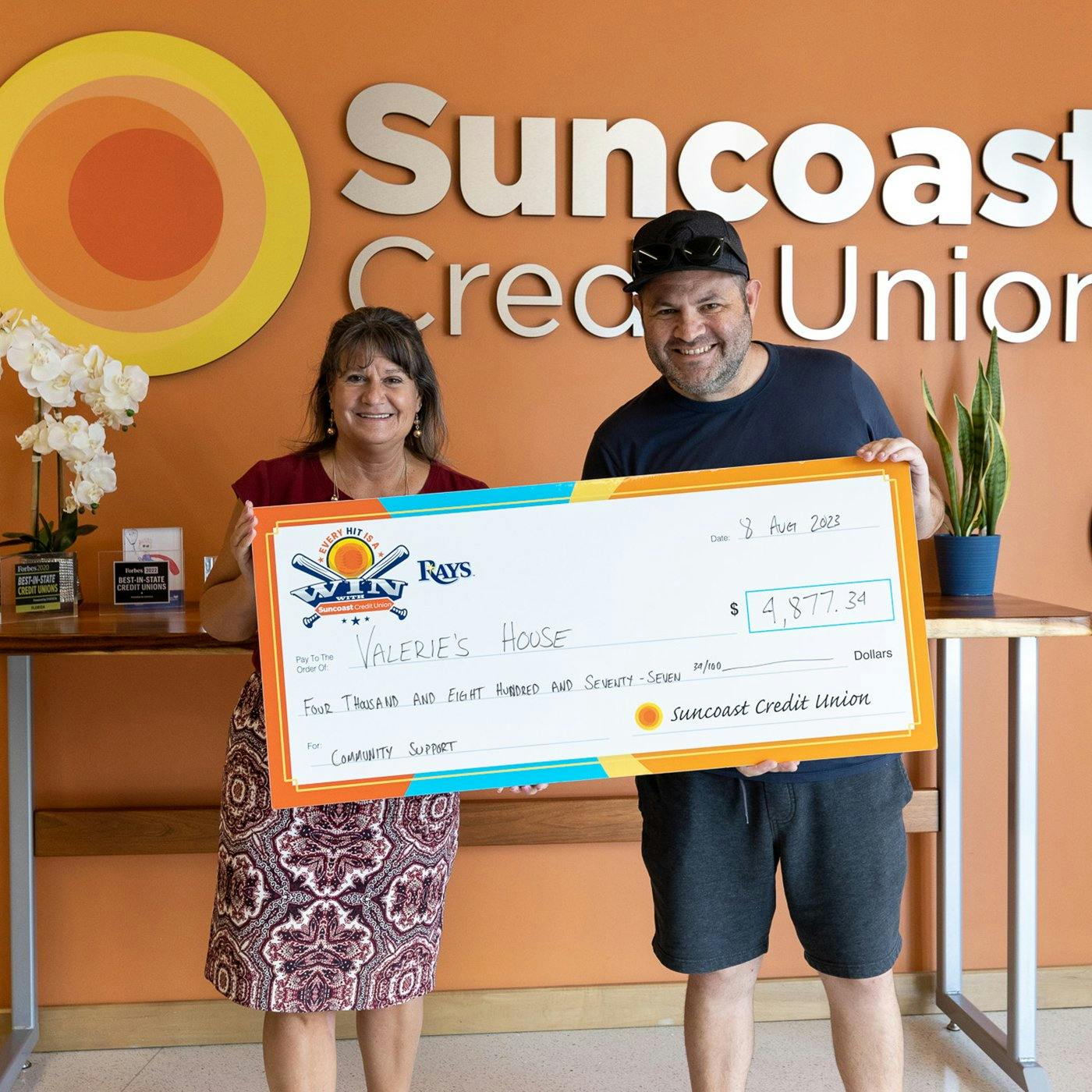 Two people holding an oversized Suncoast check