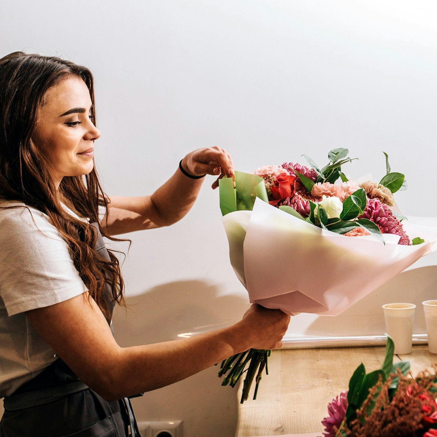 A woman assembling a boquet of flowers