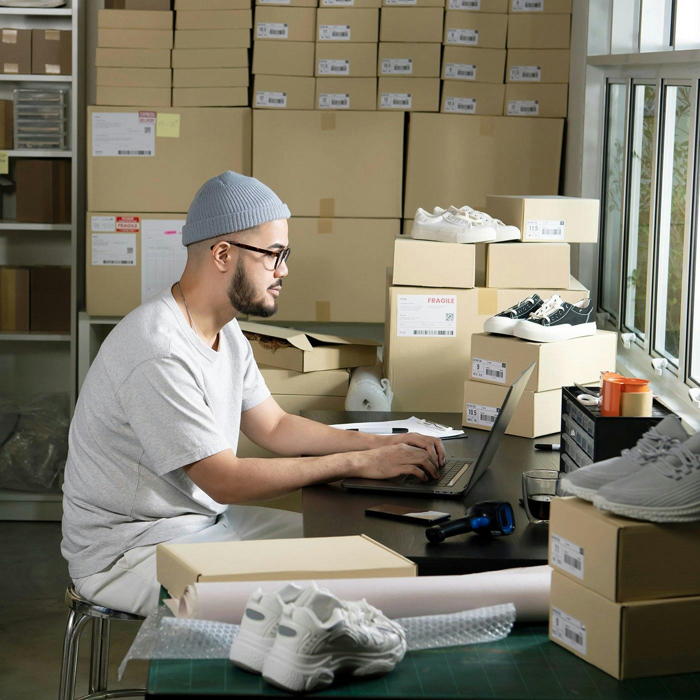 A man working on a laptop in a shipping room